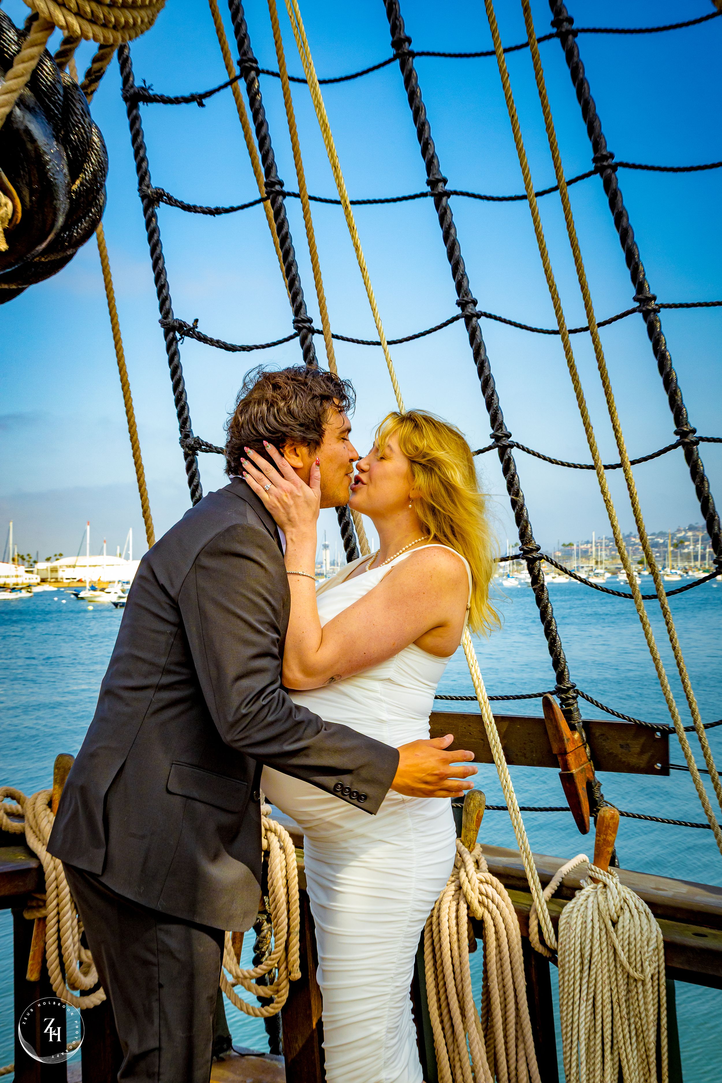 Newlyweds kissing aboard the San Salvador ship in San Diego harbor by Zeus Holbrook San Diego Wedding Photographer