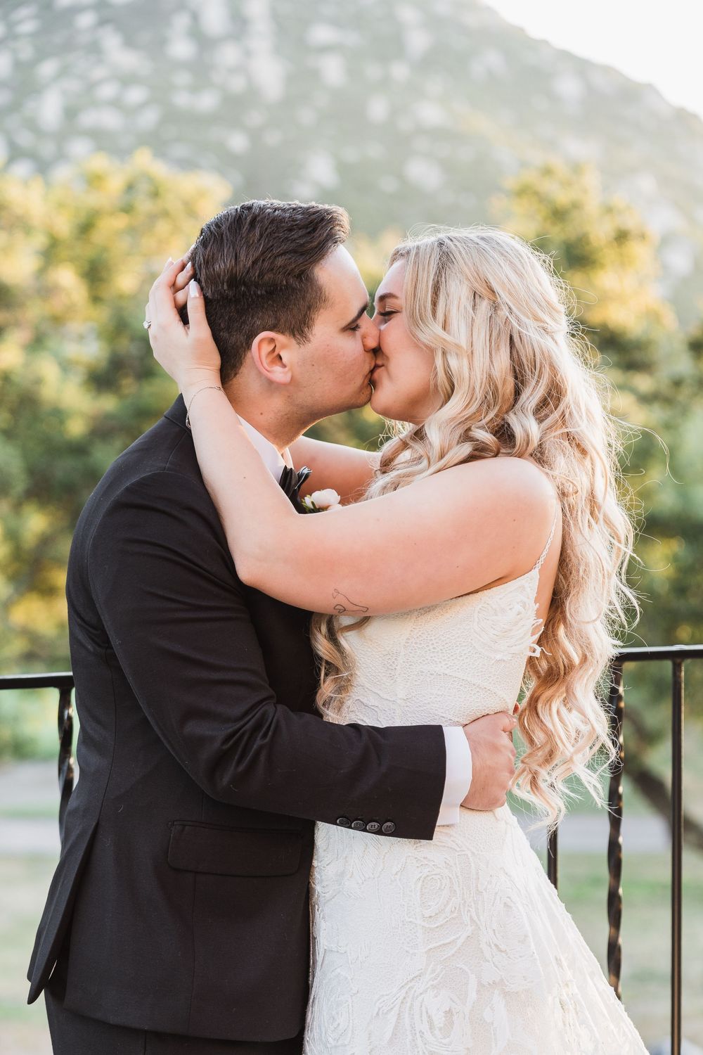 A romantic kiss sequence between newlyweds on their wedding day captured in multiple frames outdoors.