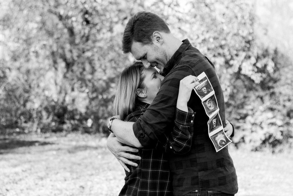 couple hugging holding ultrasound photo