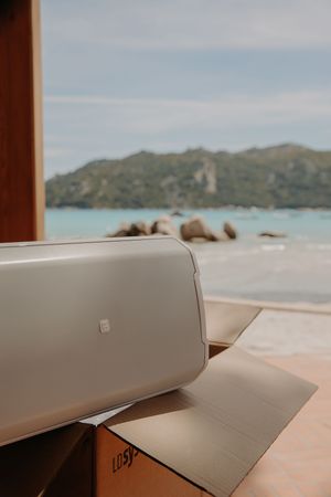 Beige surface with mountains and ocean visible in the blurred background.