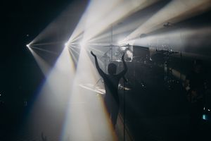 Atmospheric stage lighting creating dramatic lens flares in dark performance space.