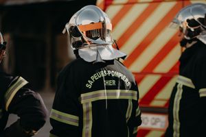 Group of firefighters in uniform standing together at an emergency scene.