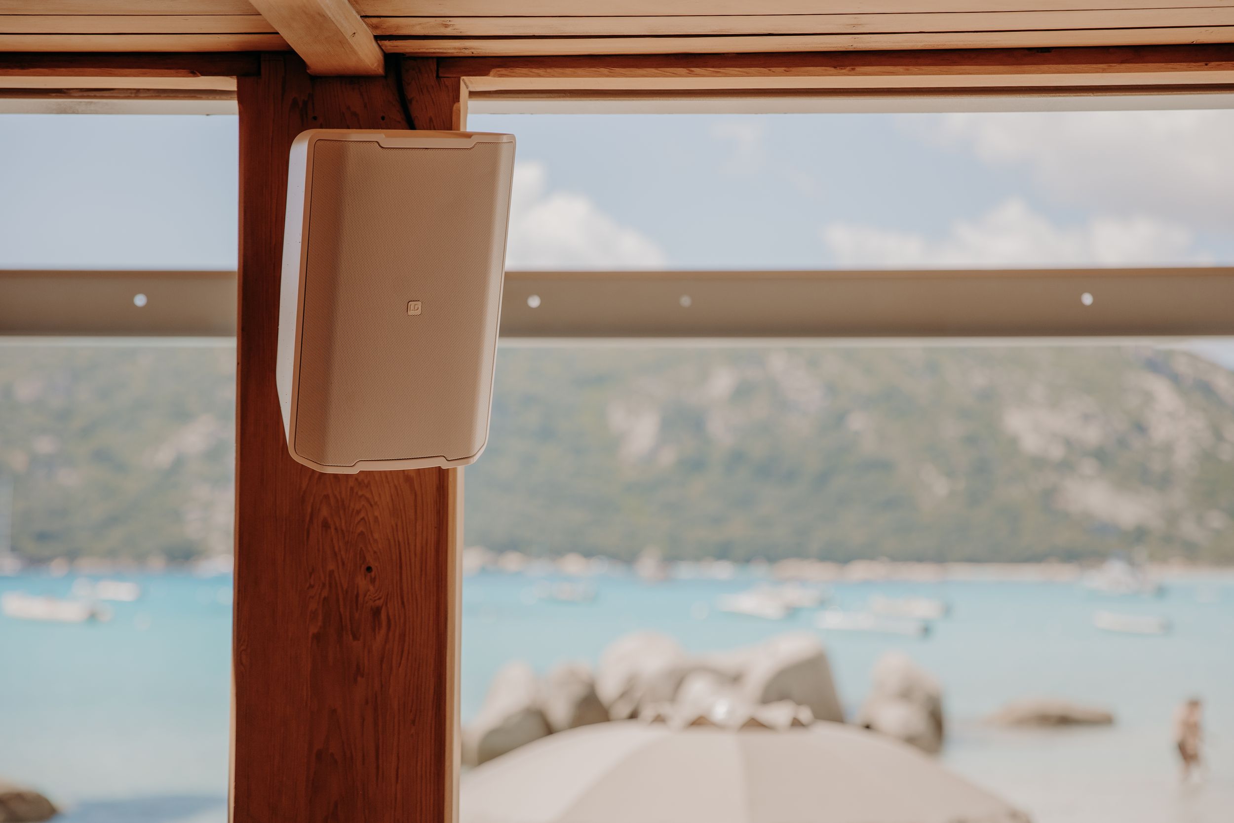 Wooden beam framing a scenic coastal view with mountains and water in the distance.