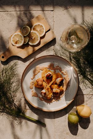 Elegant plating of a dessert with citrus garnish and fresh herbs in natural lighting.