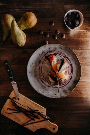Artistic plating of food on ceramic dish with wooden cutting board.