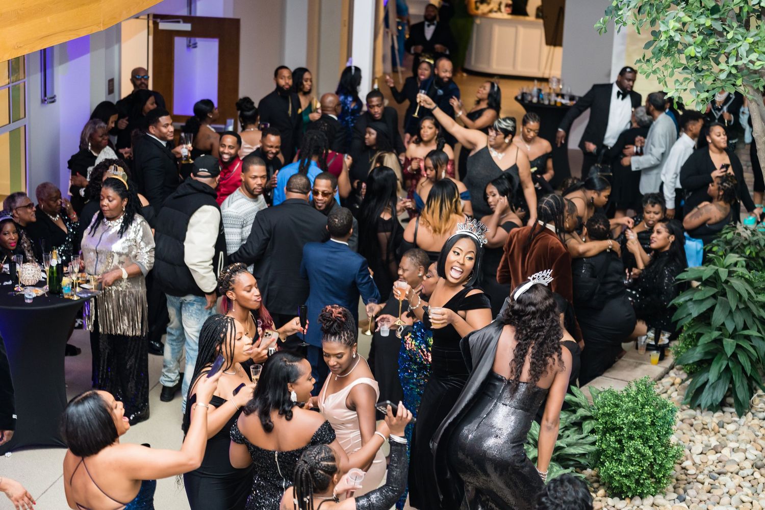 Large crowd of people dancing and socializing at a lively indoor party or event.