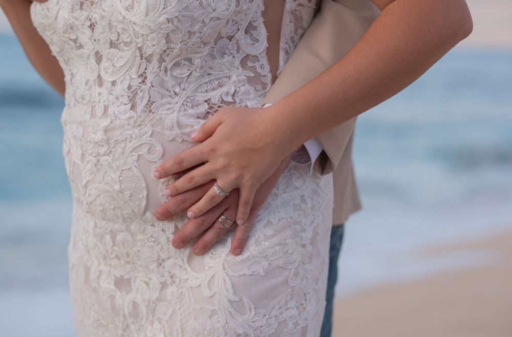 Close-up details of a white lace wedding dress on a North Shore Oahu beach during an intimate sunset wedding session.