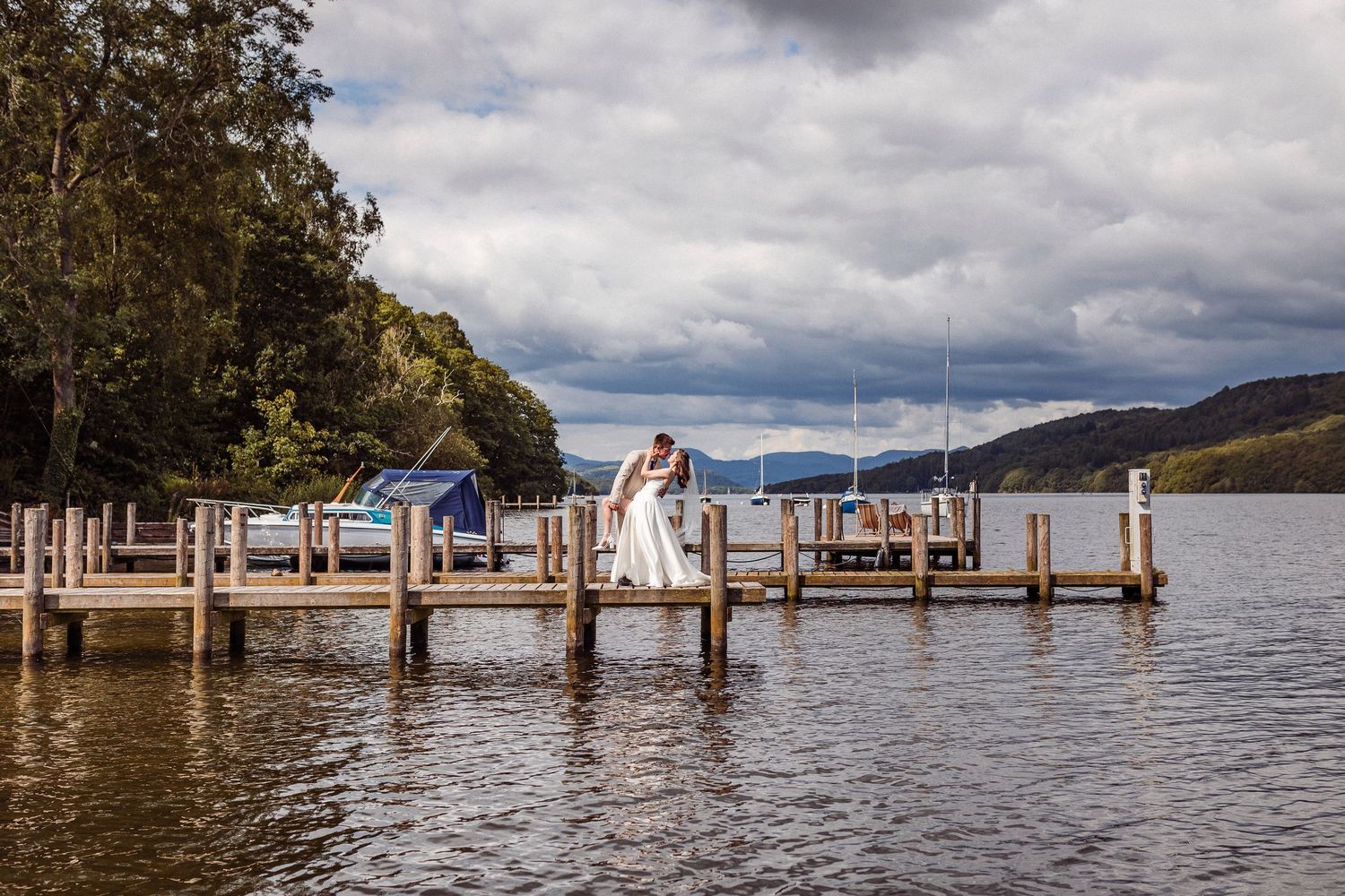 Bride and groom embrace on the jetty at Lakeside Hotel