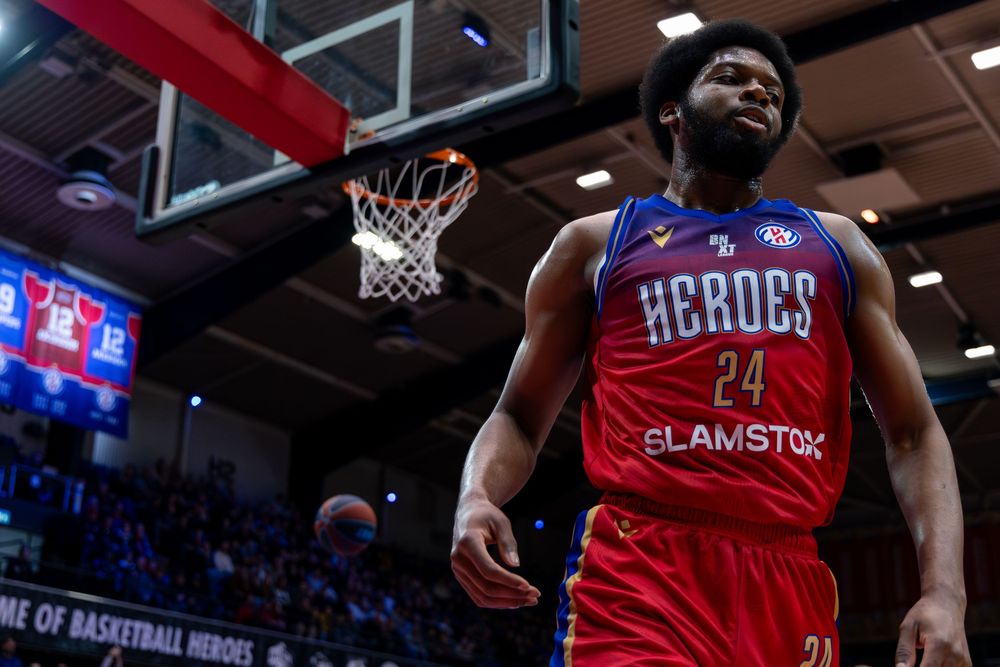 Speler Heroes Den Bosch loopt trots weg na maken van een dunk tijdens basketbalwedstrijd