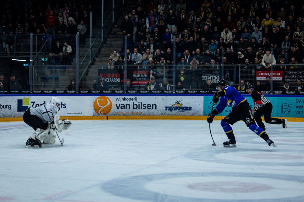 Speler schiet op doel tijdens ijshockeywedstrijd in Tilburg