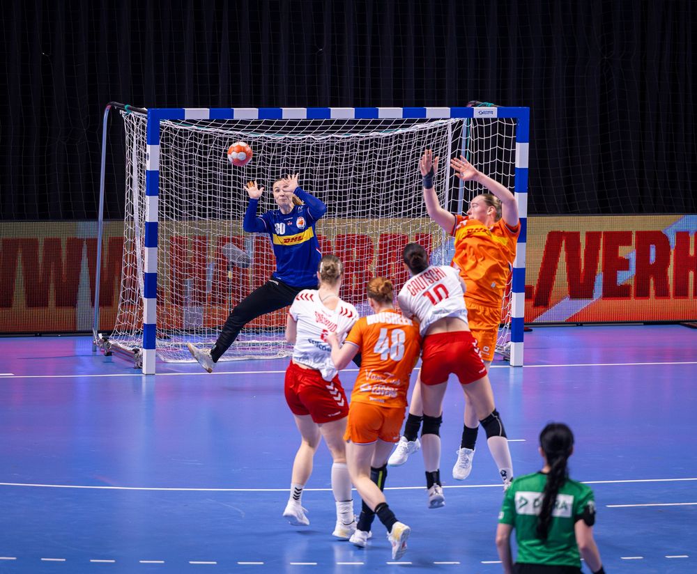 Redding van de keeper na schot op doel tijdens handbalwedstrijd