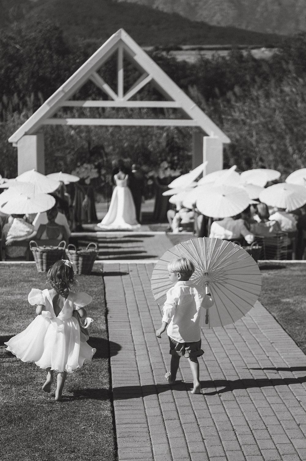 Bride and groom standing together beneath breathtaking vineyard and mountain views