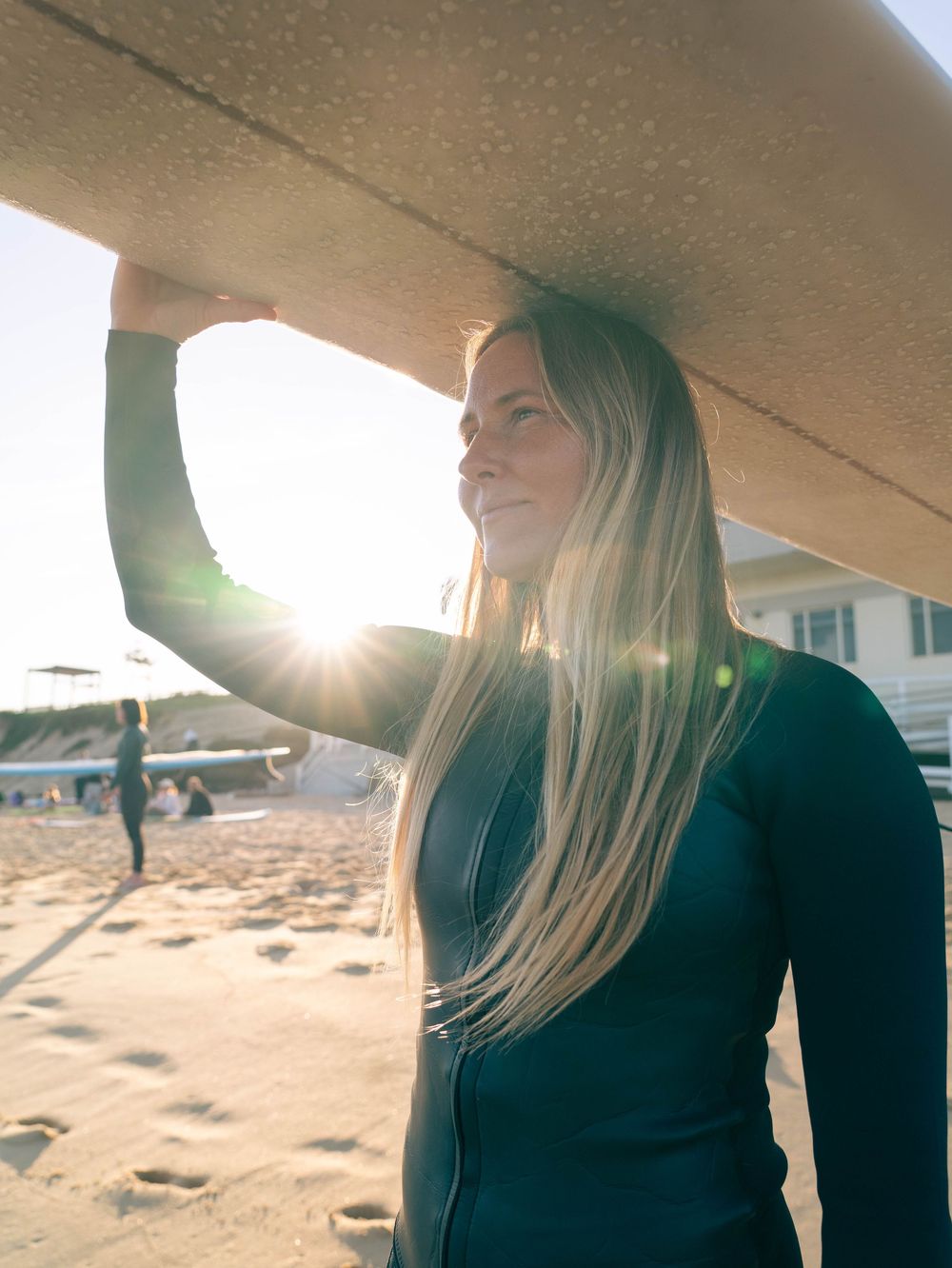 photo of a girl with longboard on head for project One Ocean 100 Lives story of girl who surfed for 3 years straight, taken at Bar Beach