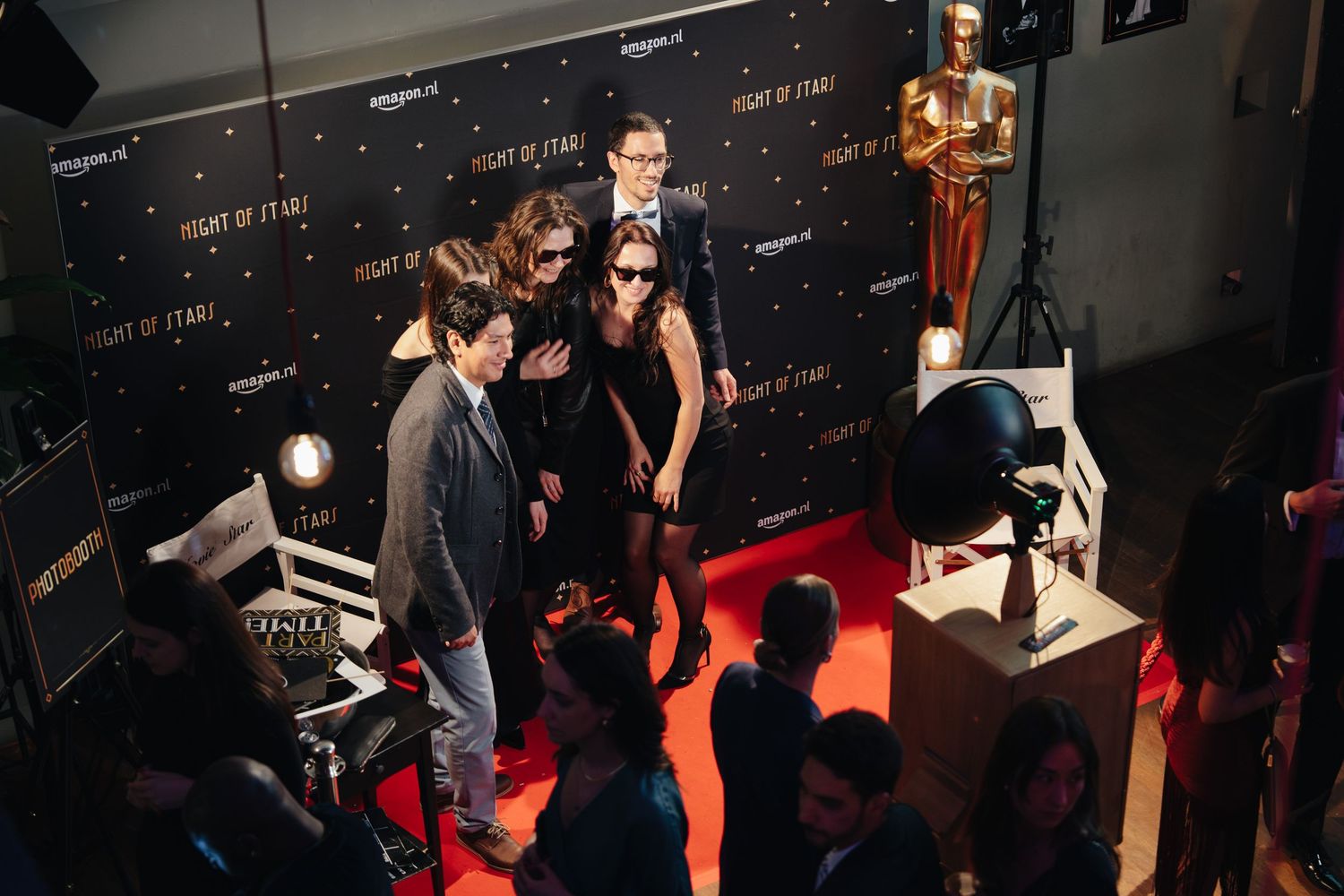 Guests posing on red carpet at Night of Stars event with Oscar statue and photographers.