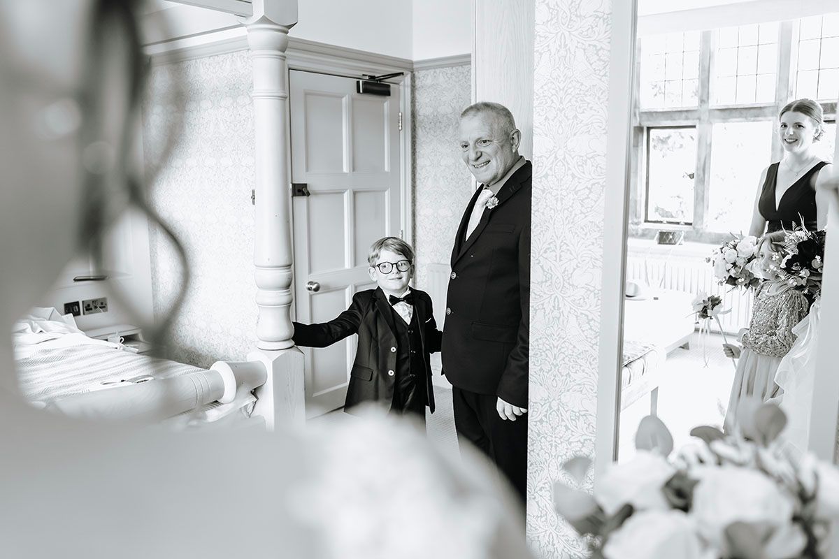 First view of the brides dress by a proud father & son at Cragwood Country House in The Lake District.