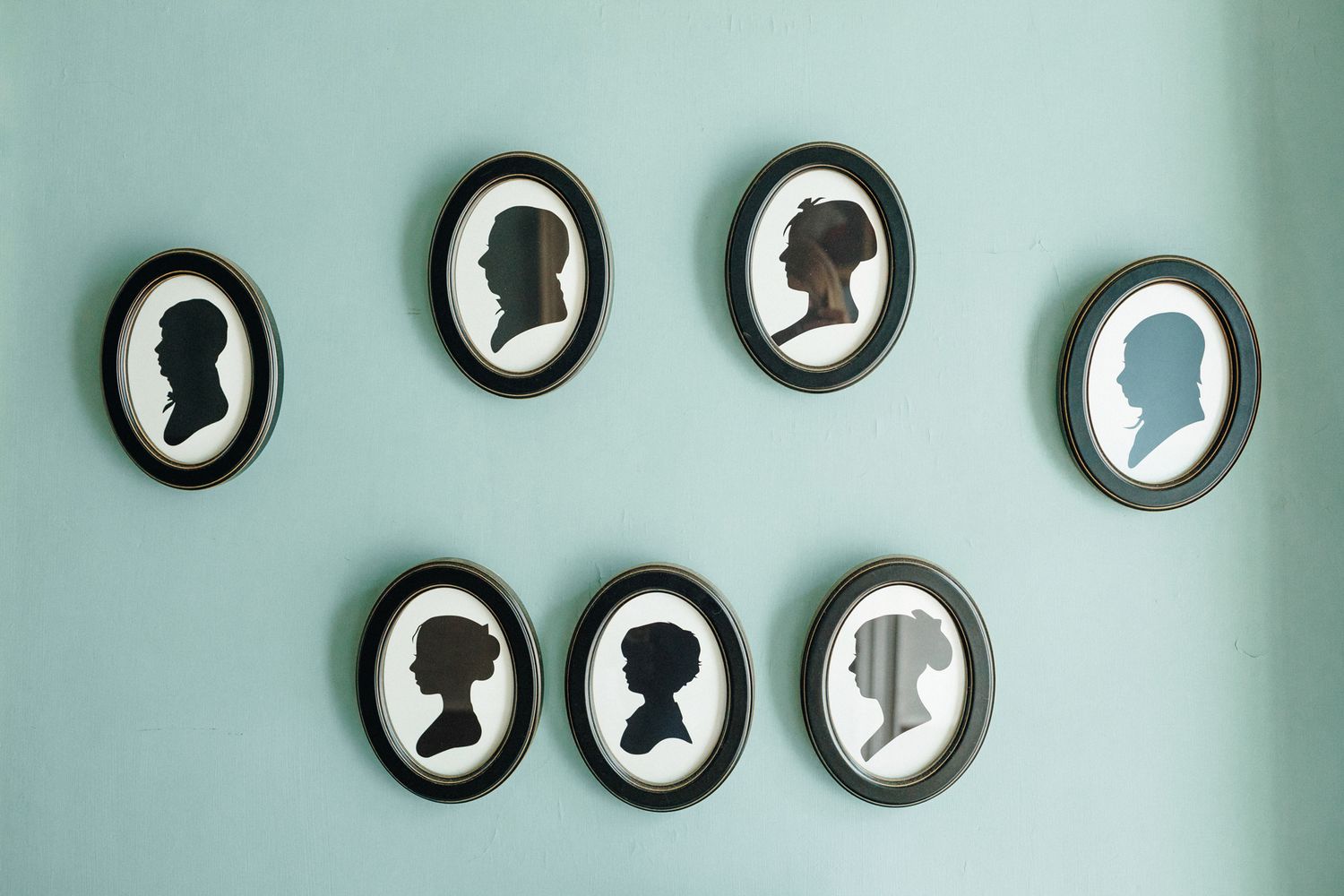 Portrait black old-fashioned silhouettes on a light muted blue-green painted wall at Strawberry Bank New Hampshire. New England photographer