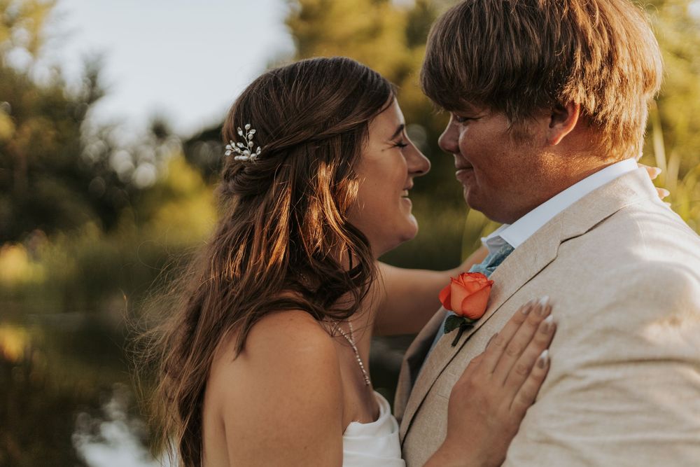 A couple shares romantic moments at sunset in a garden setting while wearing formal attire.