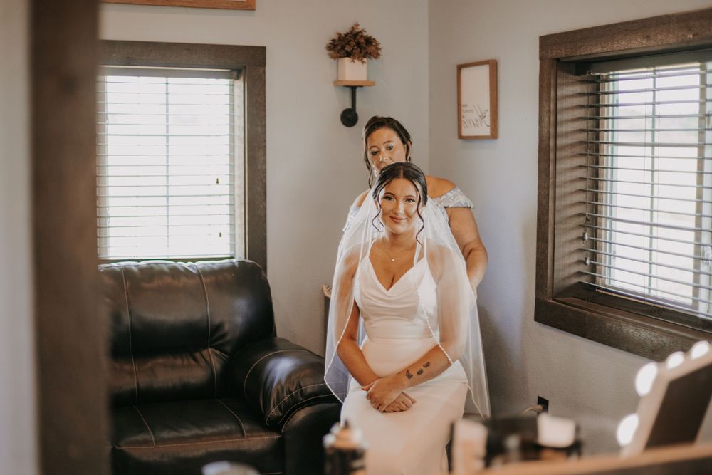 Candid wedding preparation moment captured in a sunlit room.