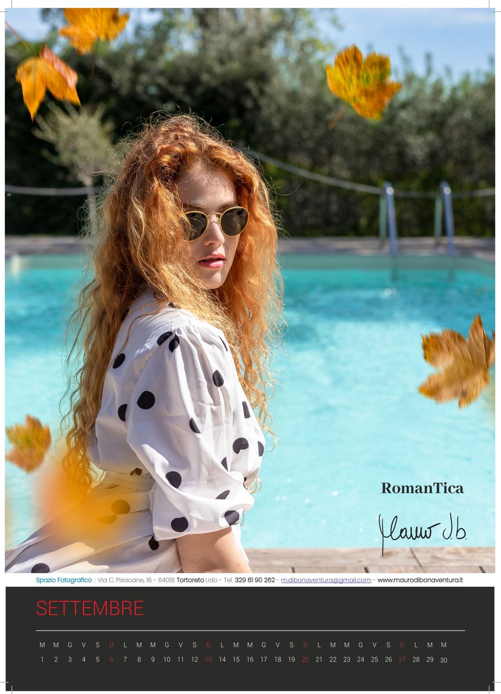 Poolside portrait with falling autumn leaves and polka dot shirt against blue water.