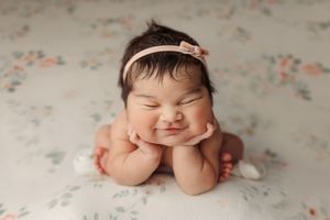 A series of five adorable newborn baby portraits showing different sweet expressions on a floral backdrop.