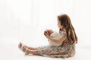 big sister holding her newborn baby sister at her newborn session in Tulsa,OK