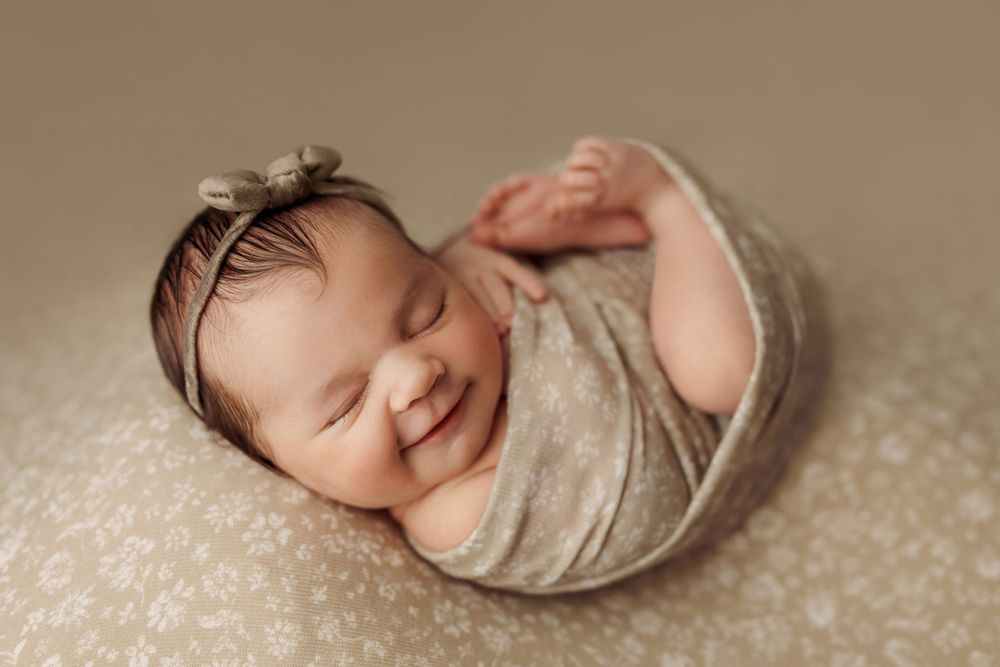 newborn-baby-girl-smiling-at-her-newborn-session