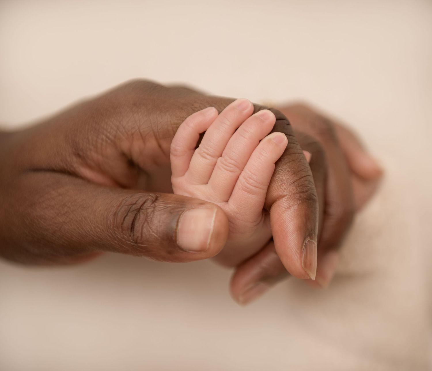 Stunning photo of a newborn baby's hand wrapped around mum's finger.