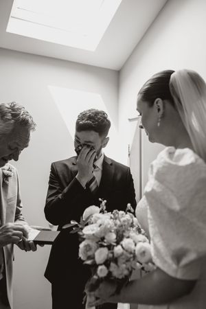 Black and white wedding photo sequence showing emotional first look reaction between bride and her brother and father.