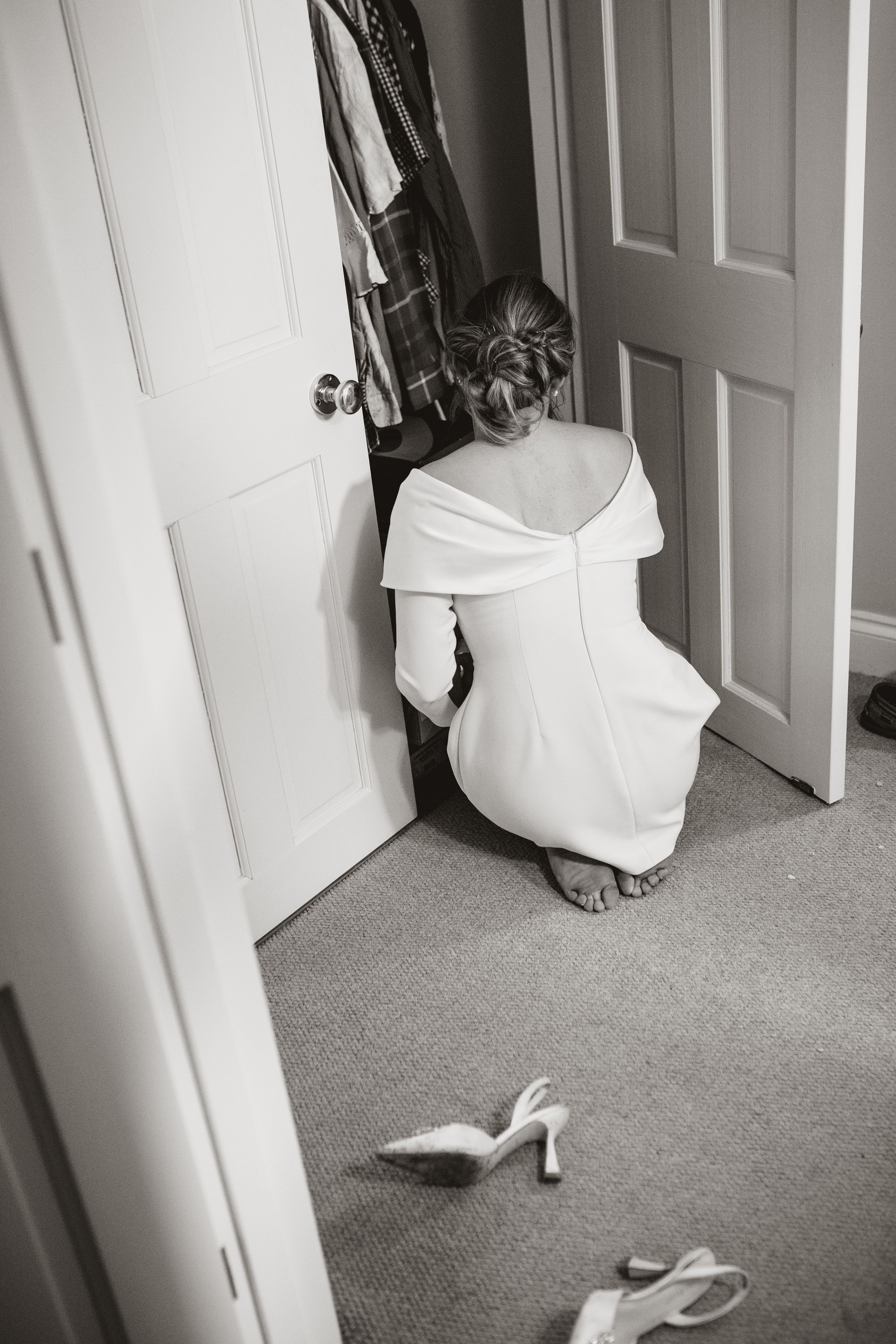 A sequence of black and white photos showing a white dress moving behind a door in a carpeted room.
