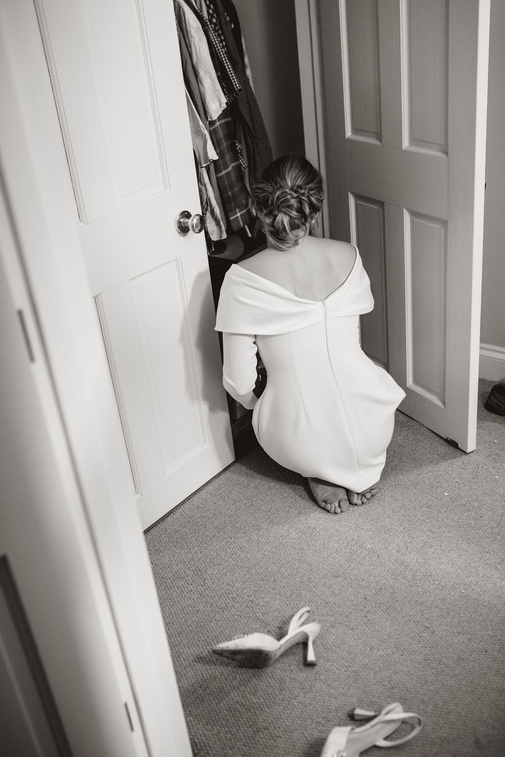 A sequence of black and white photos showing a white dress moving behind a door in a carpeted room.