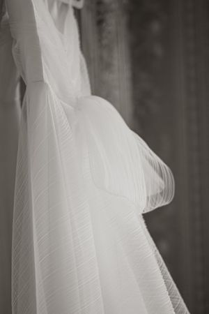 Close-up of white wedding veil fabric details in black and white photography.