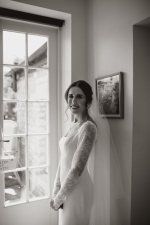 A classic bridal portrait by a window in black and white.