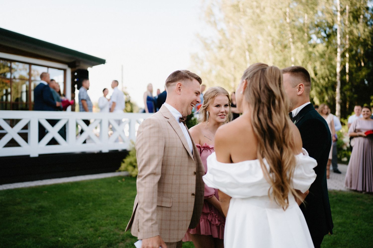 Guests enjoying a lively outdoor wedding celebration with a white gazebo in the background.