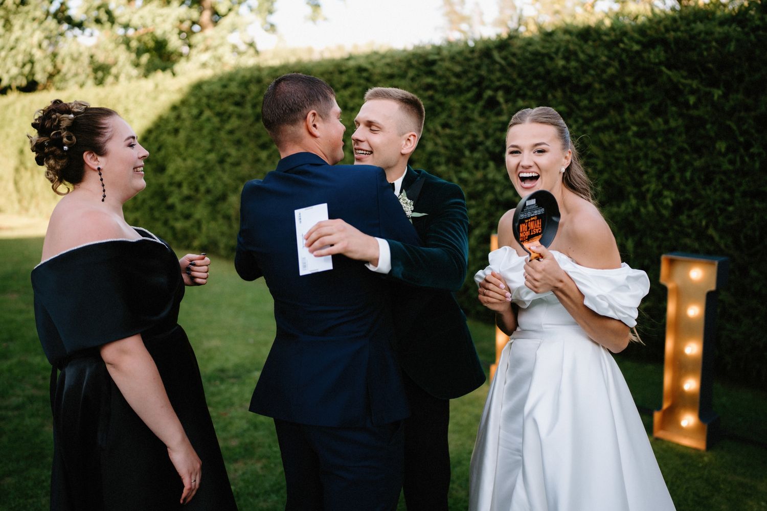 Wedding attendees dancing and embracing during an outdoor evening celebration.