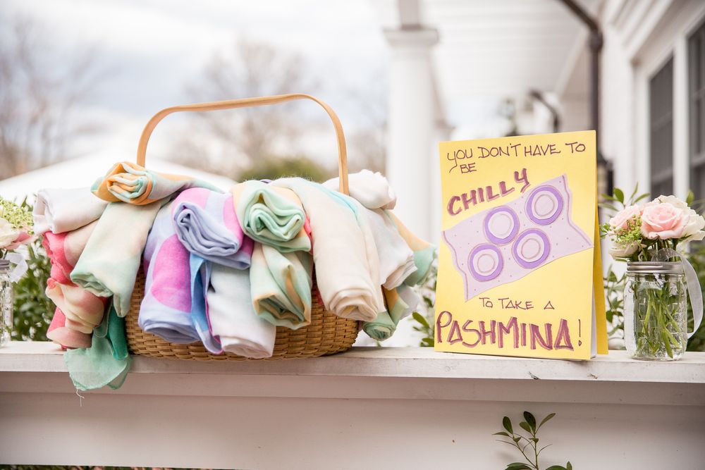 Decorative wedding signs and pastel ribbons adorn rustic baskets at a romantic reception setup.