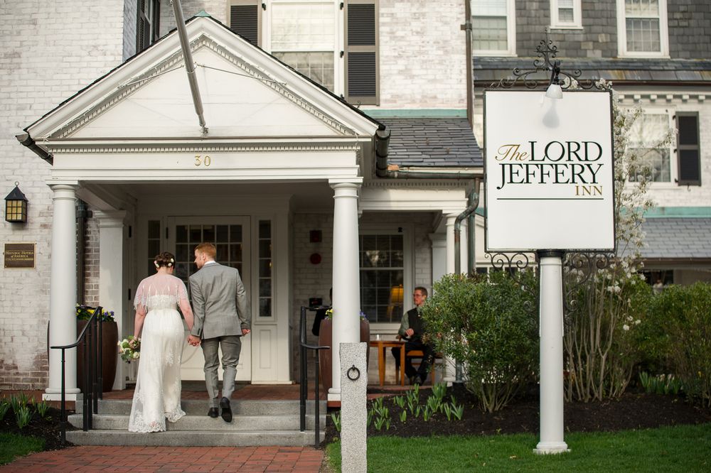 A couple exits the Lord Jeffery Inn under a white columned portico on their wedding day.