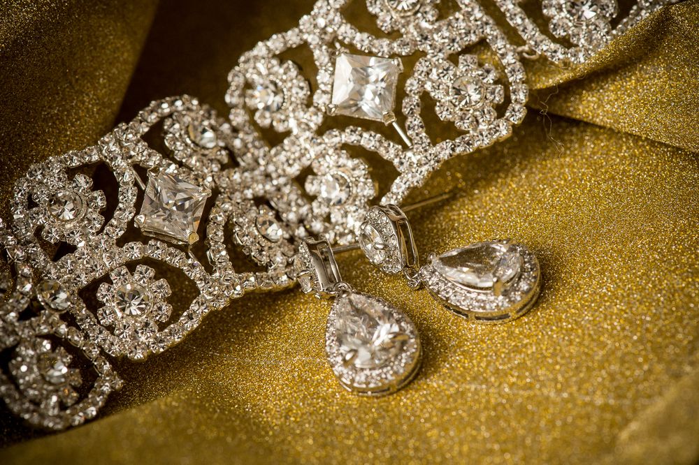 Sparkling diamond rings arranged in a line on a golden textured surface showcase elegant wedding jewelry.