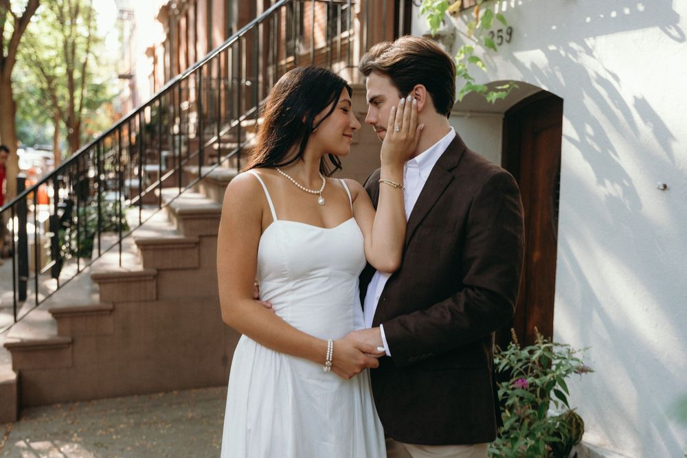 A bride and groom share intimate moments in a series of romantic wedding photos on a brownstone staircase.