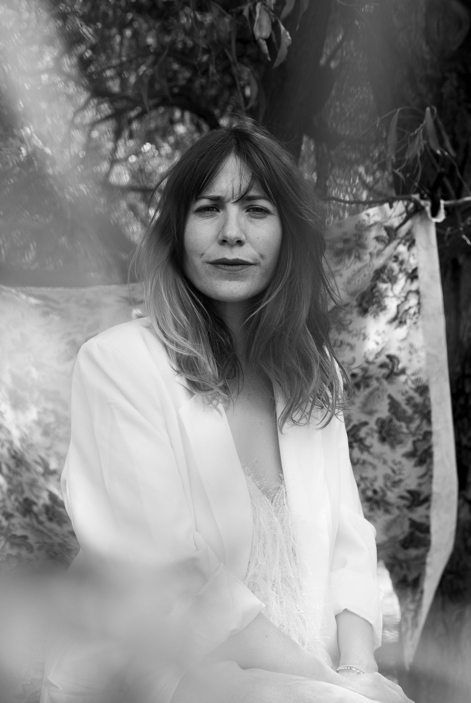 Ethereal black and white portrait series showing a dreamy figure in white clothing against a soft natural backdrop.