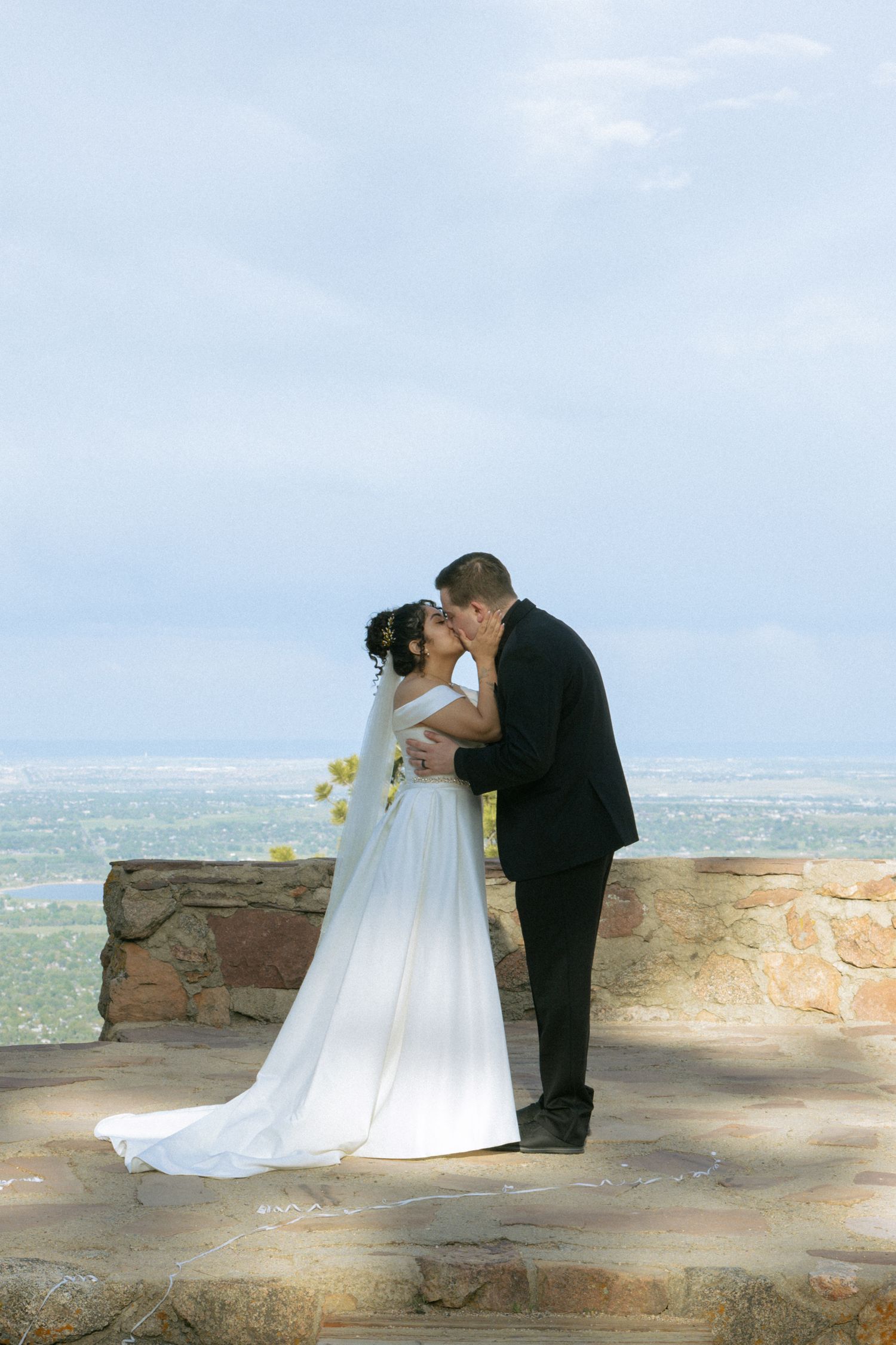 Couple exchanging vows during a micro wedding at Sunrise Amphitheater in Boulder, Colorado, surrounded by mountain views.