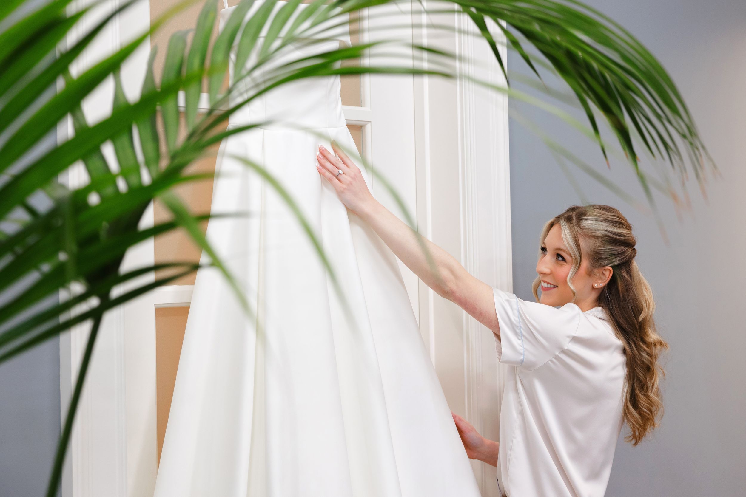 Bride adjusting dress at BallenIsles Country Club in Palm Beach, Florida during a wedding photographed by Ohio photographer Tom Forrest.