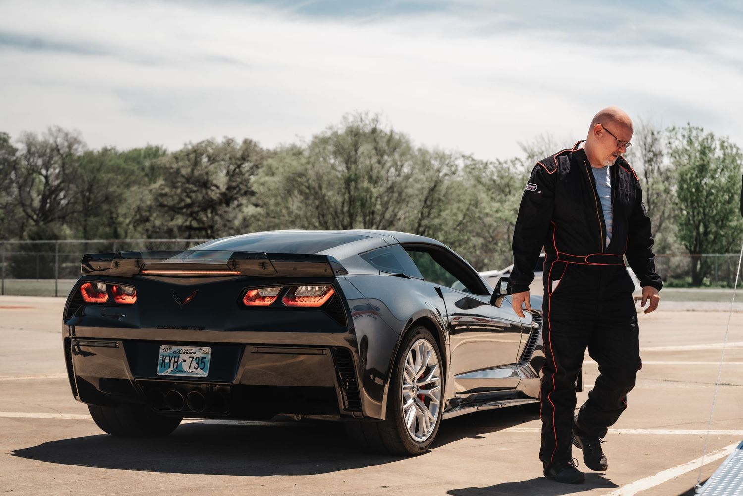 A sleek black Chevrolet Corvette photographed from multiple angles in a parking lot.