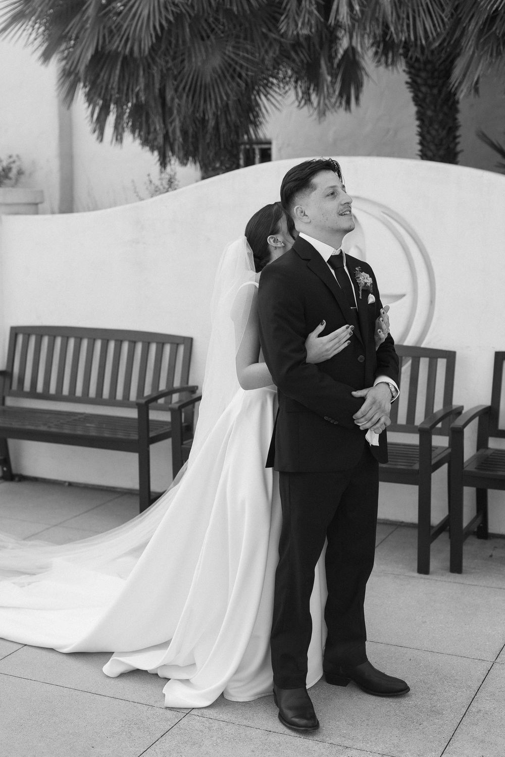 A candid black and white photo captures a first touch before a wedding in Santa Barbara.