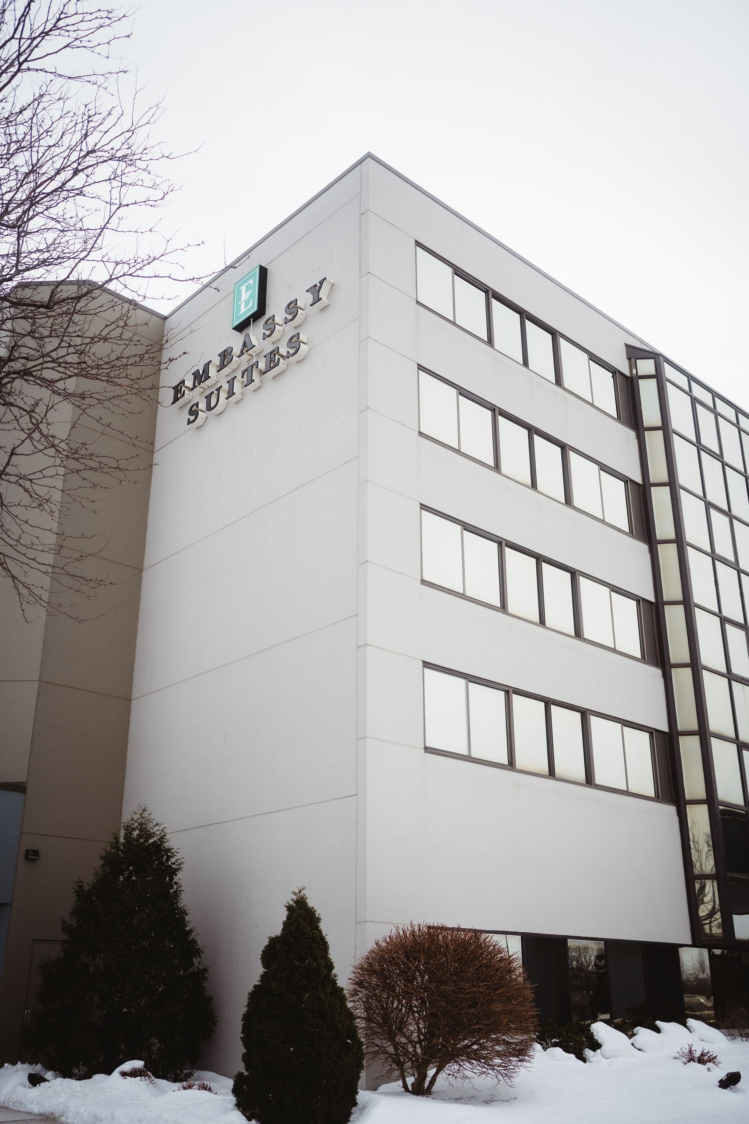 Modern white office building with angled architecture and large windows photographed from multiple angles in winter.