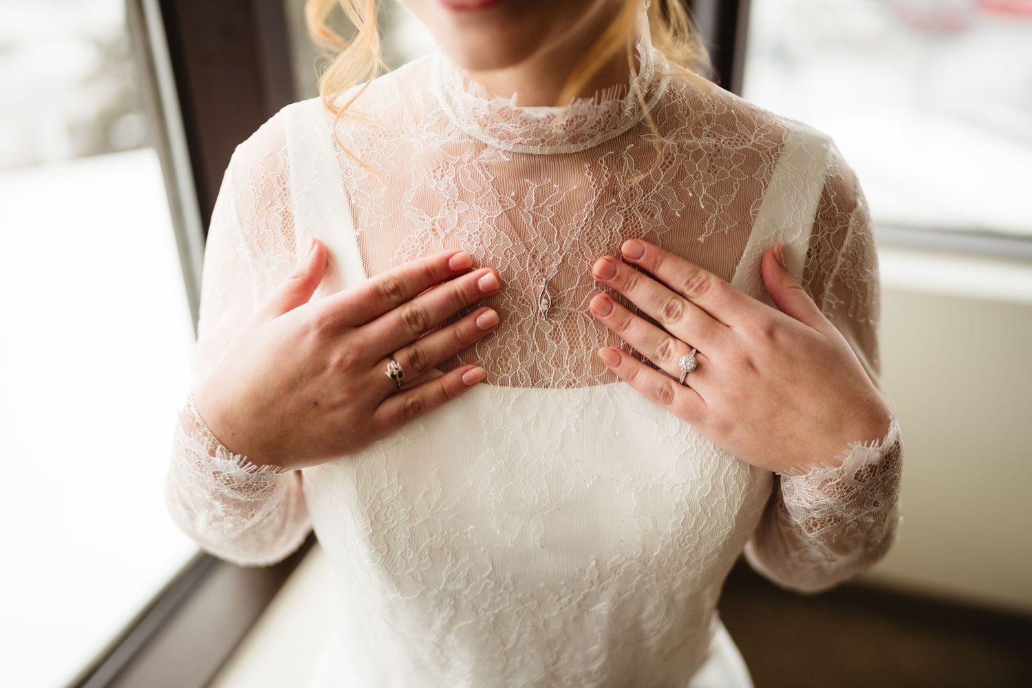 Intricate lace neckline details of an elegant white wedding gown.