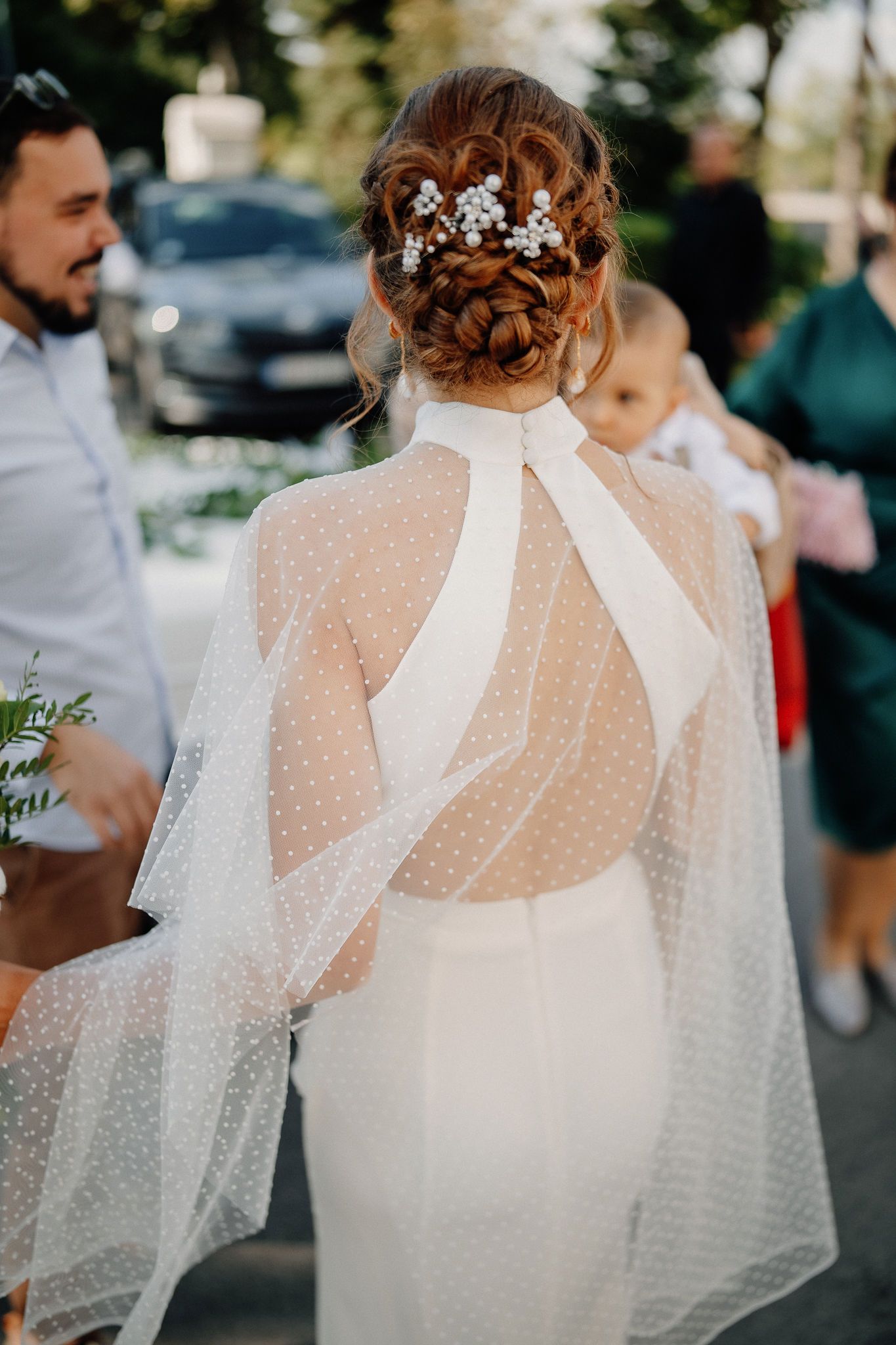 A bride wearing a delicate polka dot tulle cape over her wedding dress, shown from behind in three similar angles.
