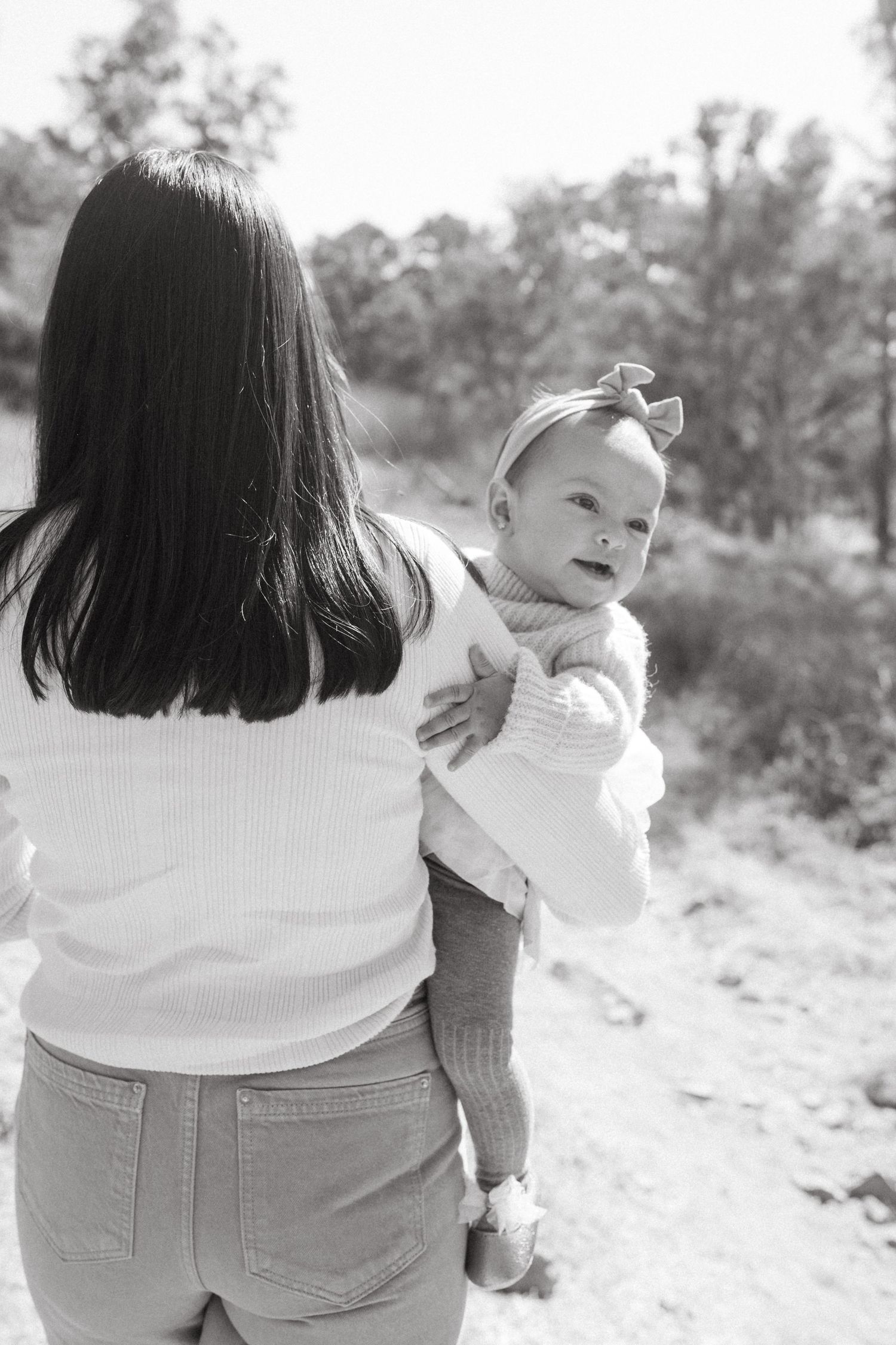Black and white photos of parent and baby in casual outdoor setting.