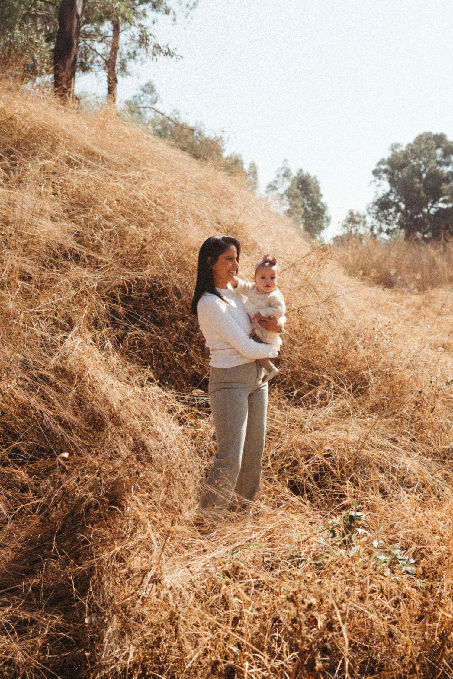 Intimate family portrait session on a rustic hillside with natural lighting.