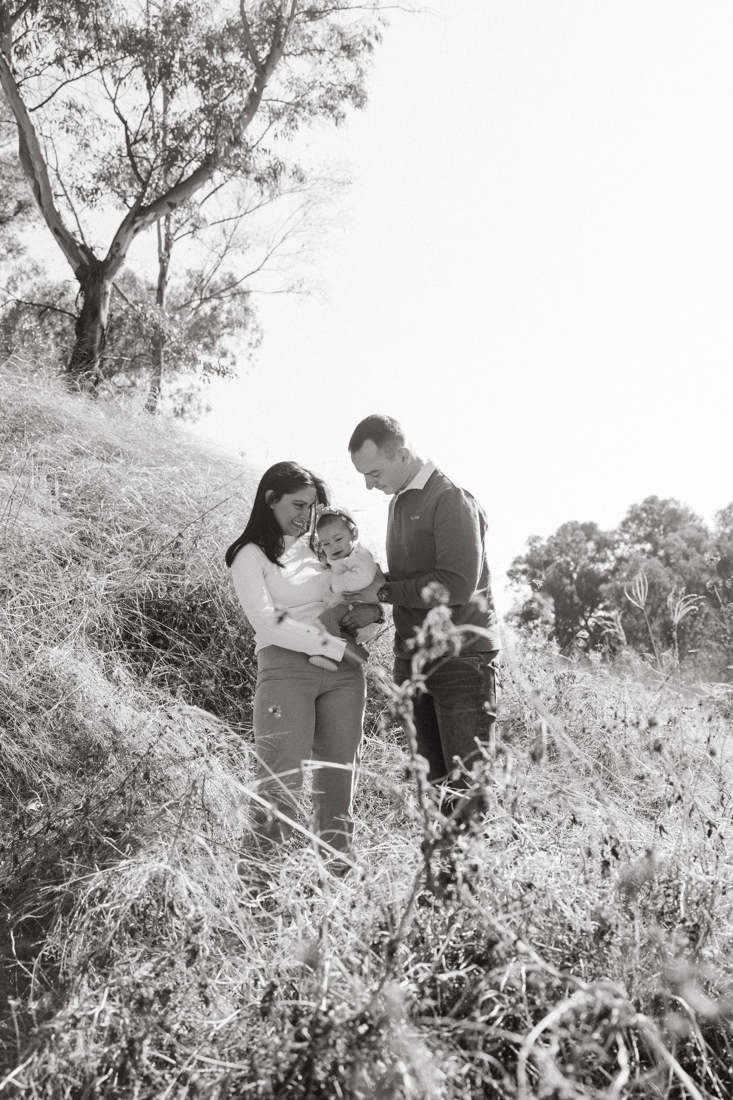 Black and white family portrait showing tender moments in nature.