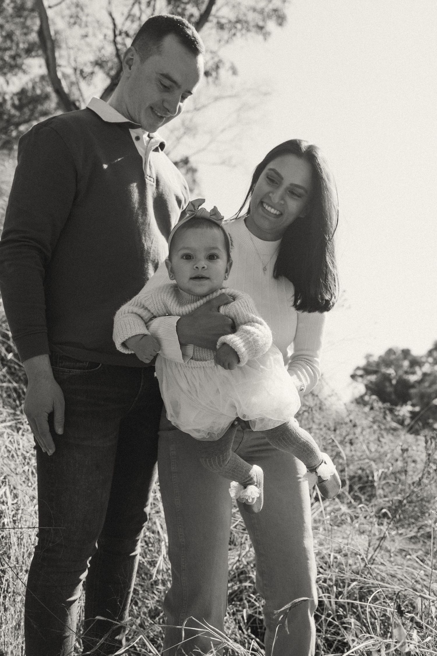 Black and white candid family portrait showing genuine laughter and connection.